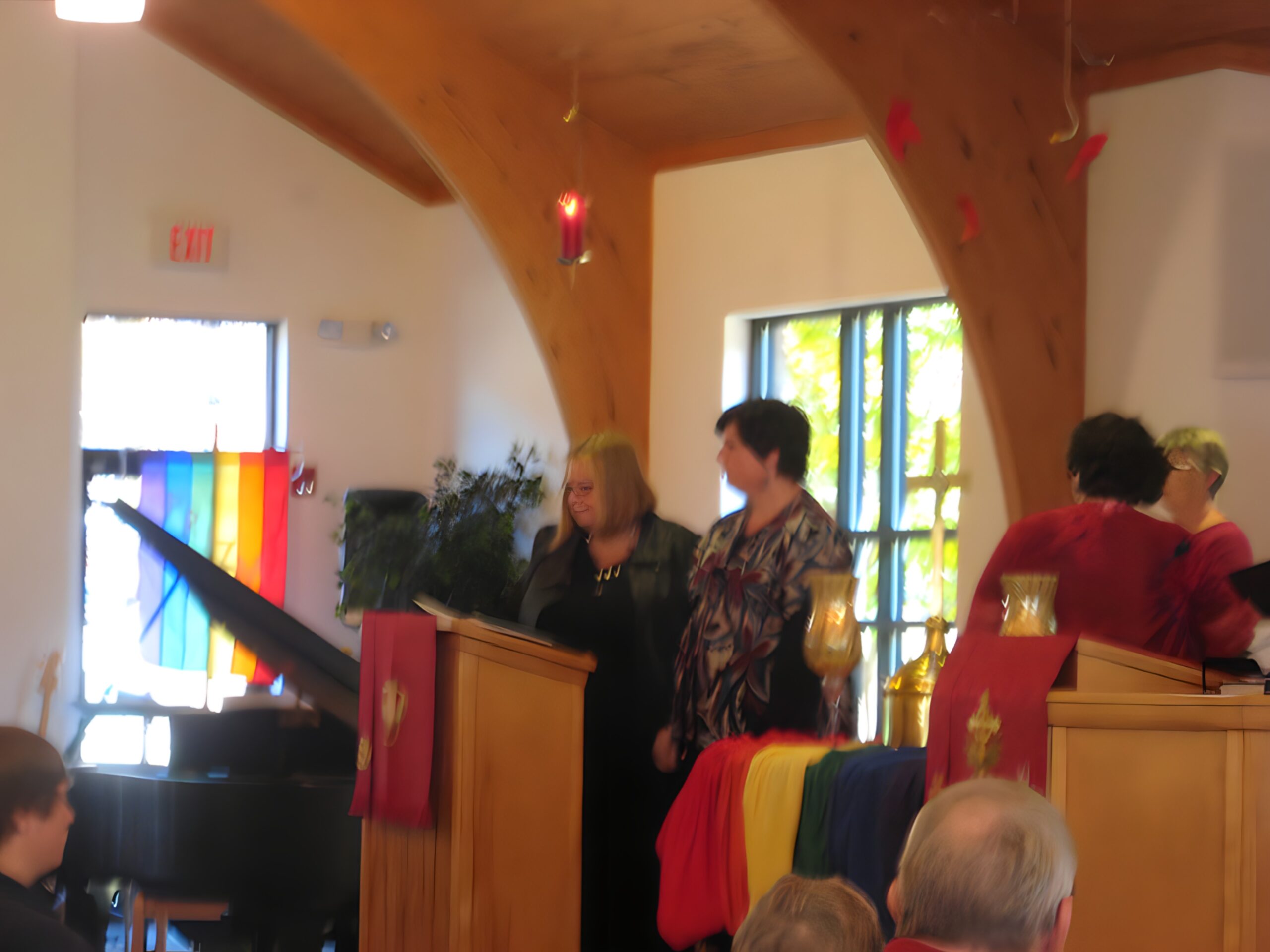 Altar adorned with rainbow cloths and members preparing for service.