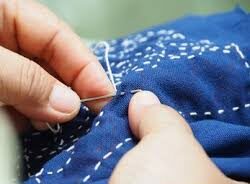 Colorful threads woven together with hands, symbolizing love, nurture, and community in the Ministry of Mothering.