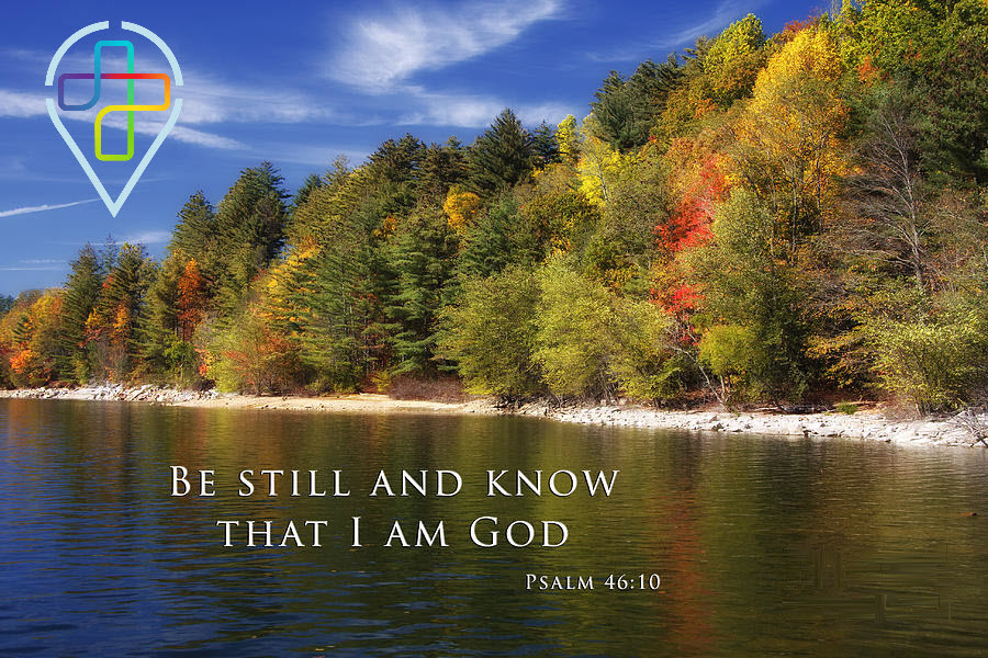 Peaceful lakeside scene with autumn-colored trees reflected in the calm water, overlaid with the Holy Covenant UCC logo and the words “Be still and know that I am God – Psalm 46:10.