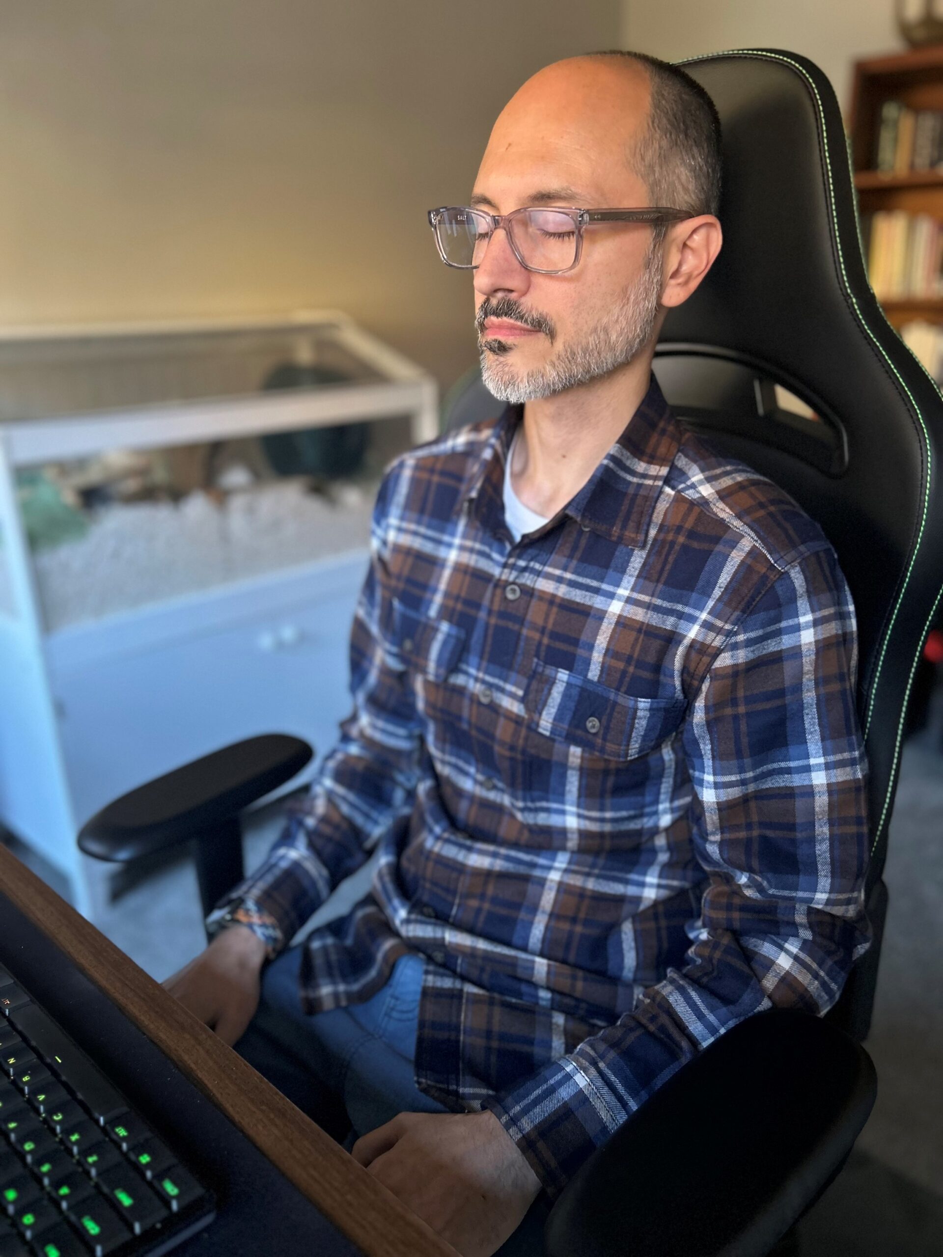 Pastor Chris seated quietly in prayer, eyes closed, practicing Centering Prayer as morning light fills his study.