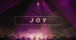 The Advent candle of joy glowing warmly.