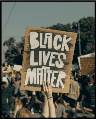 A protest crowd holds a sign reading 'Black Lives Matter,' symbolizing public witness for justice and dignity.